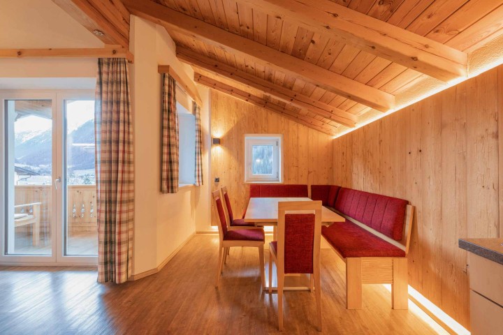Gemütliches Wohnzimmer mit einer Couch, einem Tisch und einer Flasche Wein, ideal für entspannte Abende.