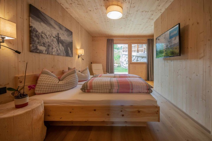 A bedroom with wooden walls and a bed that creates a cozy and inviting atmosphere.