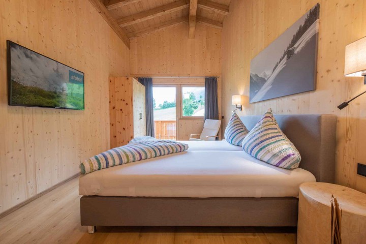 Doppelzimmer mit Bett und TV sowie Zugang zum Balkon