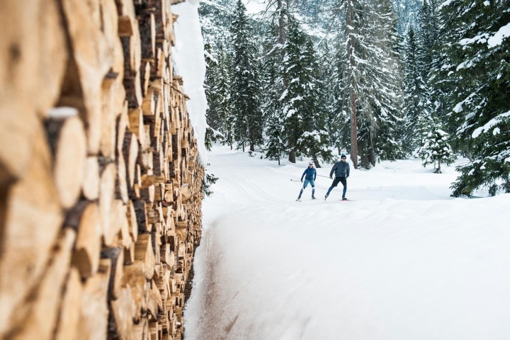 Two people go cross-country skiing in the snow in the Stubai Valley and enjoy the wintry landscape.