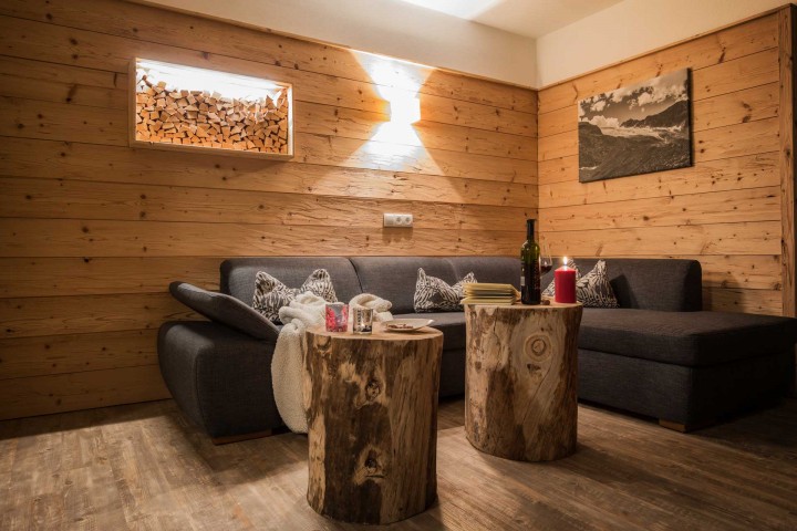 Cozy living room with a sofa and a table made of tree trunks, ideal for relaxation and social gatherings.