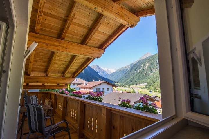Balcony view of impressive mountains, surrounded by colorful flowers that create an idyllic scenery