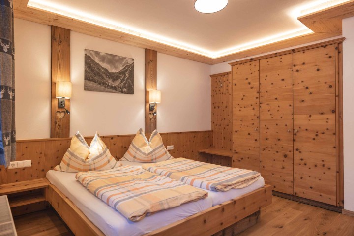 Gemütlicher Raum mit zwei Betten und Zugang zum Balkon, ideal zum Entspannen und Ausruhen.