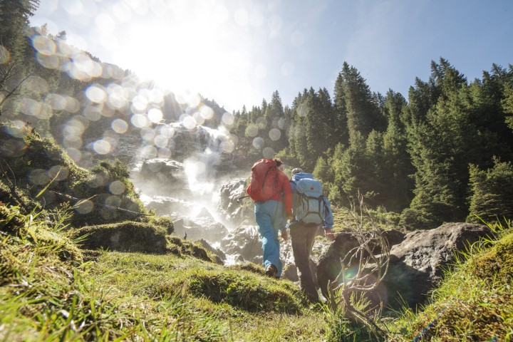 Eine Familie wandert im Stubaital, im Hintergrund sind die majestätischen Tiroler Berge zu sehen.