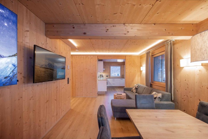 Living and dining area with direct access to the kitchen. Walls and ceilings are clad in wood