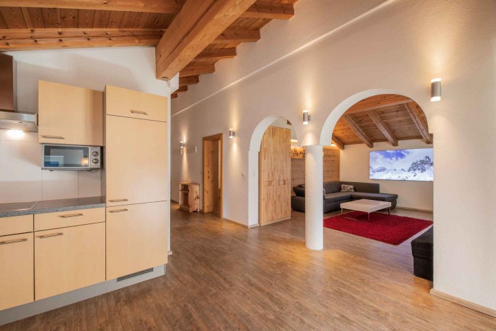Cozy kitchen and living room in a ski chalet that offers a warm atmosphere for winter vacations.