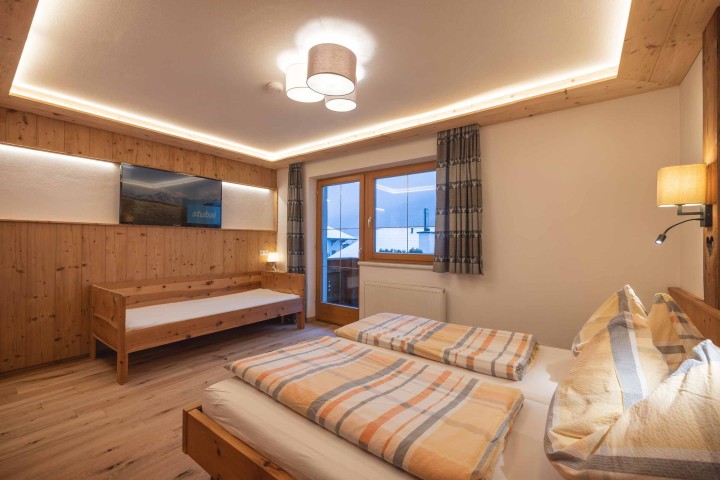  Ein Flur mit Holzböden, der zu einem Badezimmer führt, das eine einladende Atmosphäre ausstrahlt.