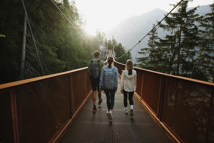 Suspension bridge in the Stubai Valley, Tyrol. 3 hikers cross the bridge.