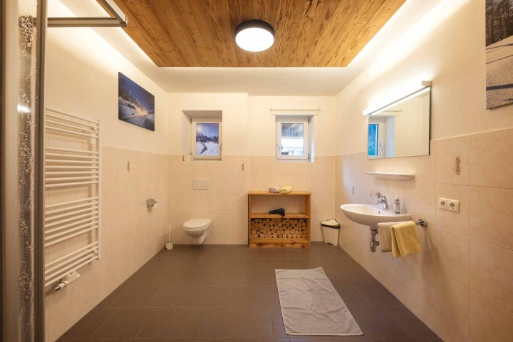 Helles Bad mit flauschigem Teppich, Dusche, WC, Waschbecken und Fenster