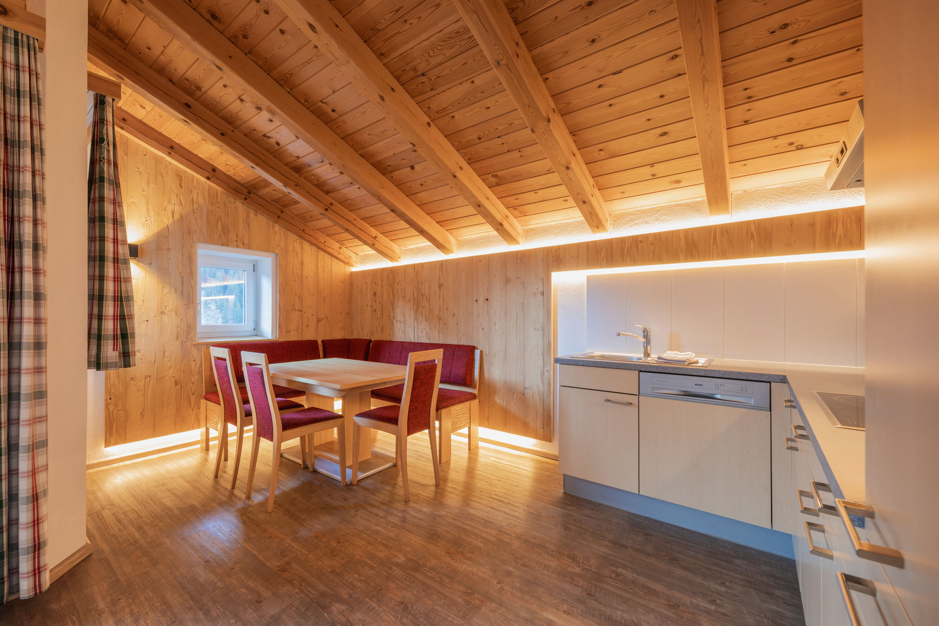 Ferienwohnung Adlerhorst: Gemütliches Wohnzimmer in der Ferienwohnung Adlerhorst mit Sofa, TV und rotem Teppich. Unterkunft im Stubaital, Tirol.