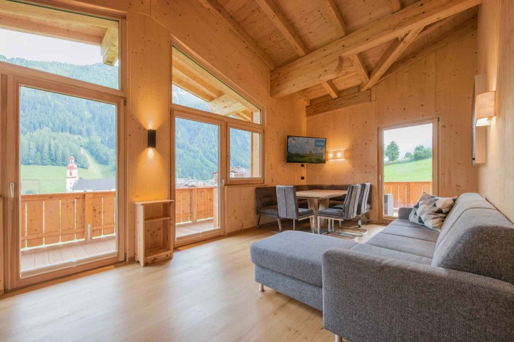 Wohn- und Essbereich mit Zugang zum Balkon. Inneneinrichtung mit Holz