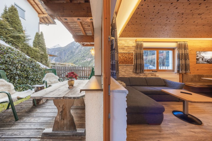 A wooden terrace on a house that provides an inviting outdoor space for relaxing and socializing.