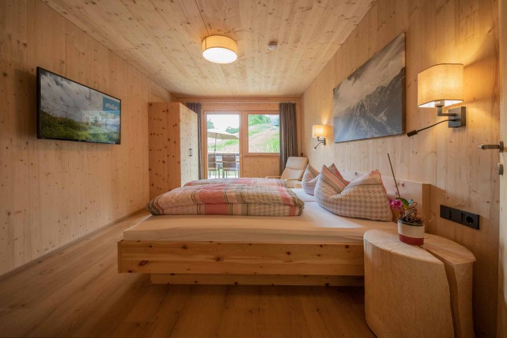A bedroom with wooden walls and a bed that creates a cozy and inviting atmosphere