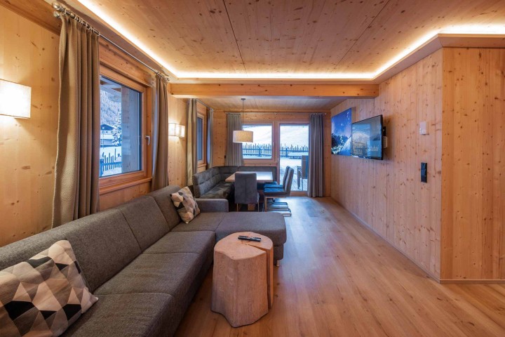 Living and dining area with sofa, table and chairs and access to the balcony