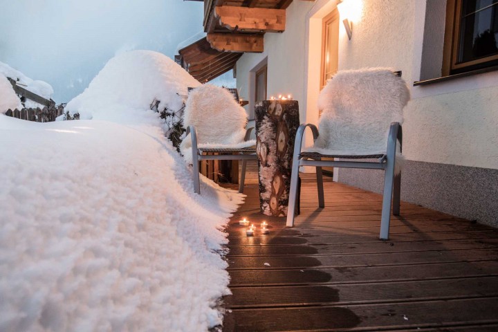 Balkon bedeckt mit Schnee mit gemütlicher Sitzgelegenheit